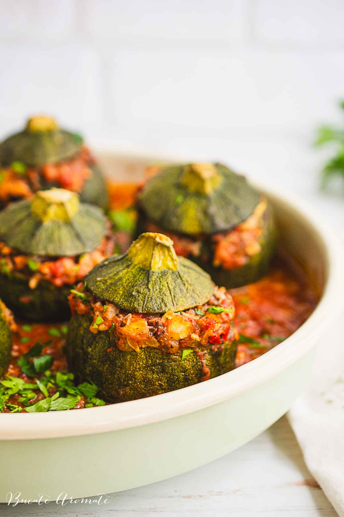 tava cu dovlecei rotunzi umpluti, gatiti in sos de rosii, presarati cu patrunjel