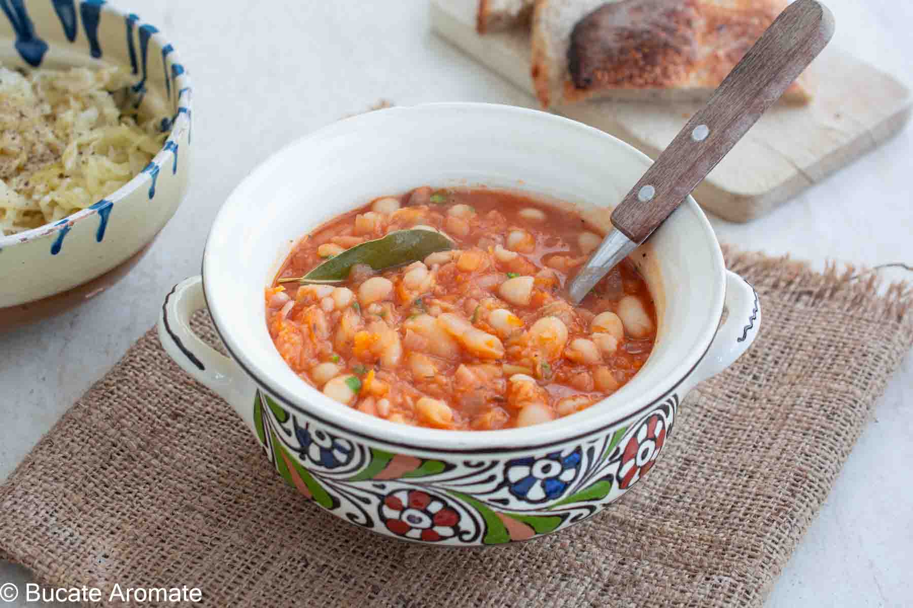 Iahnie de fasole de post cu sos de roșii, fasole fiartă și legume, servită alături de varză murată și pâine coaptă