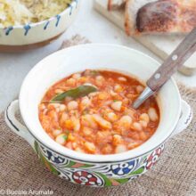 Iahnie de fasole boabe, cremoasă și aromată, într-un bol tradițional, decorată cu frunză de dafin