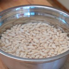 Fasole boabe albă hidratată în apă rece pentru o fierbere mai rapidă și mai ușor de digerat