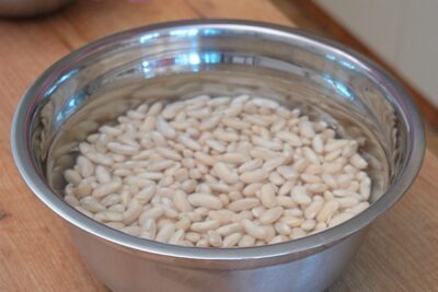 Fasole boabe albă hidratată în apă rece pentru o fierbere mai rapidă și mai ușor de digerat