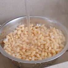 Fasole albă fiartă, clătită sub apă curentă pentru a elimina spuma și substanțele iritante