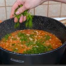 Mâncare de fasole cu sos tomat și legume, presărată cu pătrunjel proaspăt pentru un plus de aromă