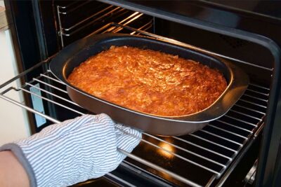 Plăcintă grecească Portokalopita rumenită în tavă, proaspăt scoasă din cuptor