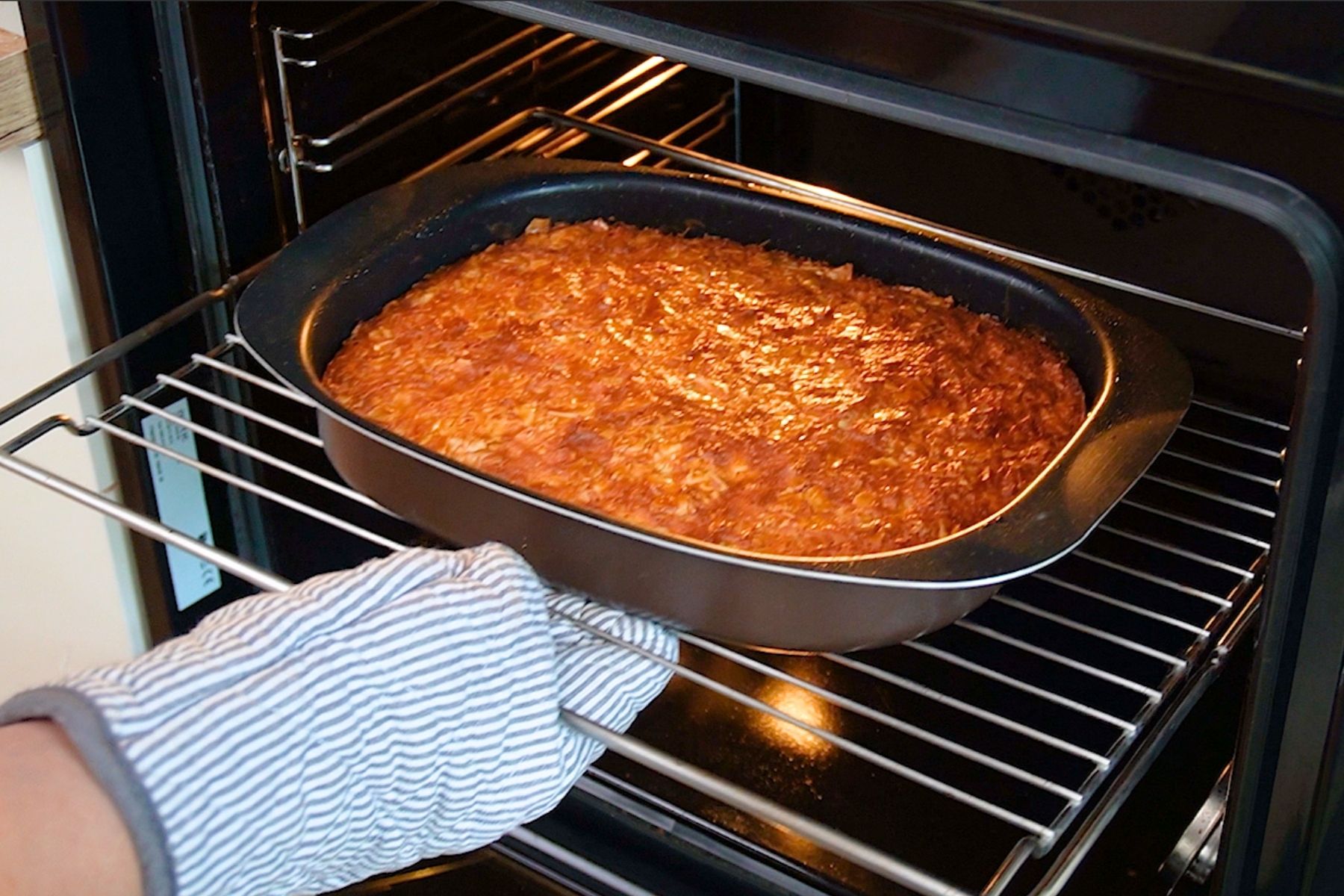 Plăcintă grecească Portokalopita rumenită în tavă, proaspăt scoasă din cuptor