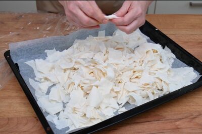 Foi subțiri de plăcintă rupte și uscate pentru Portokalopita, pregătite pe tavă