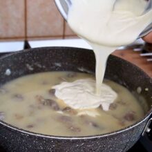 Adăugarea smântânii temperate în sosul pentru ciulama de pipote și inimi