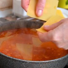 Foi de lasagna rupte bucăți și puse direct în sosul de roșii din tigaie