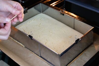 Blat vegan copt în tavă de 20 × 30 cm, verificat cu scobitoarea înainte de a fi scos din cuptor.