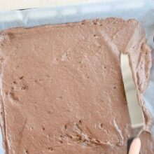 Întinderea aluatului de blat de cacao în tavă pentru tortul cu mascarpone și vișine.