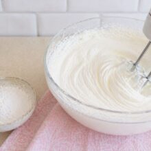 Frișcă naturală mixată cu zahăr pudră până devine fermă și cremoasă, pentru spuma de căpșuni