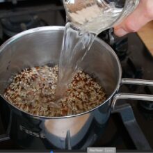 Se toarnă apă peste quinoa pentru fierbere, primul pas în pregătirea umpluturii pentru vinete.