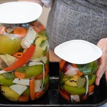 Borcan mare și borcan mic cu murături asortate în saramură, lăsate la fermentat pe masă