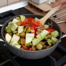 Cuburi de dovlecel și ardei kapia roșu adăugate în ghiveciul de legume, direct peste vinete și alte legume călite