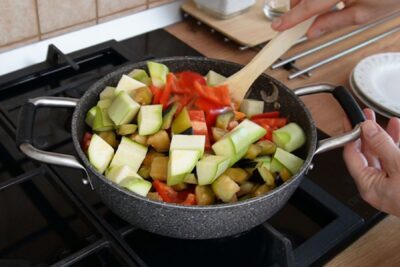 Cuburi de dovlecel și ardei kapia roșu adăugate în ghiveciul de legume, direct peste vinete și alte legume călite