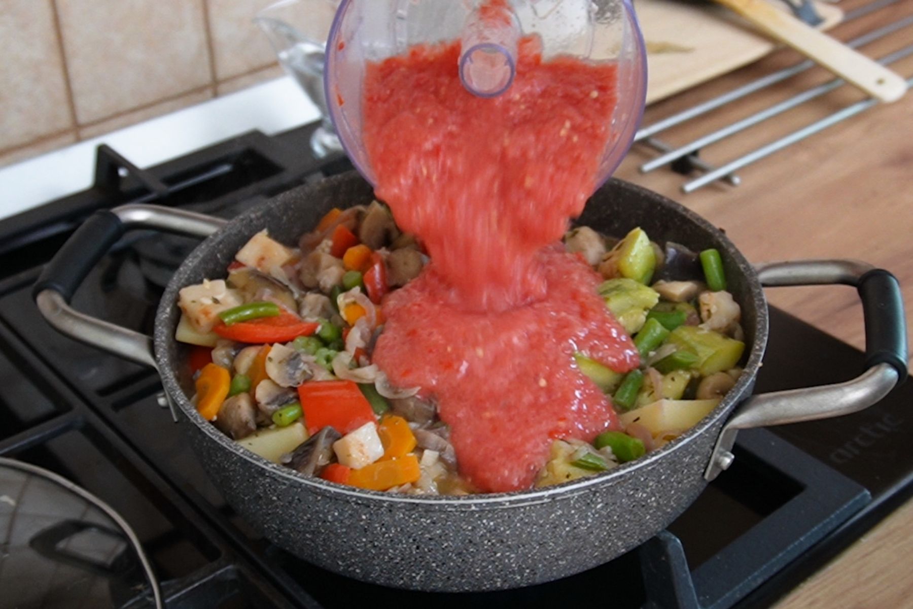 Roșii pasate adăugate în ghiveciul de legume pentru a crea un sos natural, fără apă suplimentară