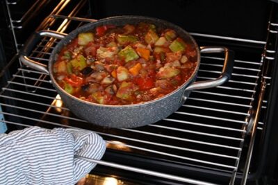 Cratiță cu ghiveci de legume pusă în cuptor pentru coacere, pentru un gust intens și legume bine pătrunse