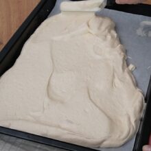 Aluatul pentru blatul de ruladă este nivelat în tava de 30x40 cm înainte de coacere