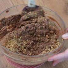 Crocantul de nuci caramelizate se încorporează în crema ganache pentru rulada cu ciocolată