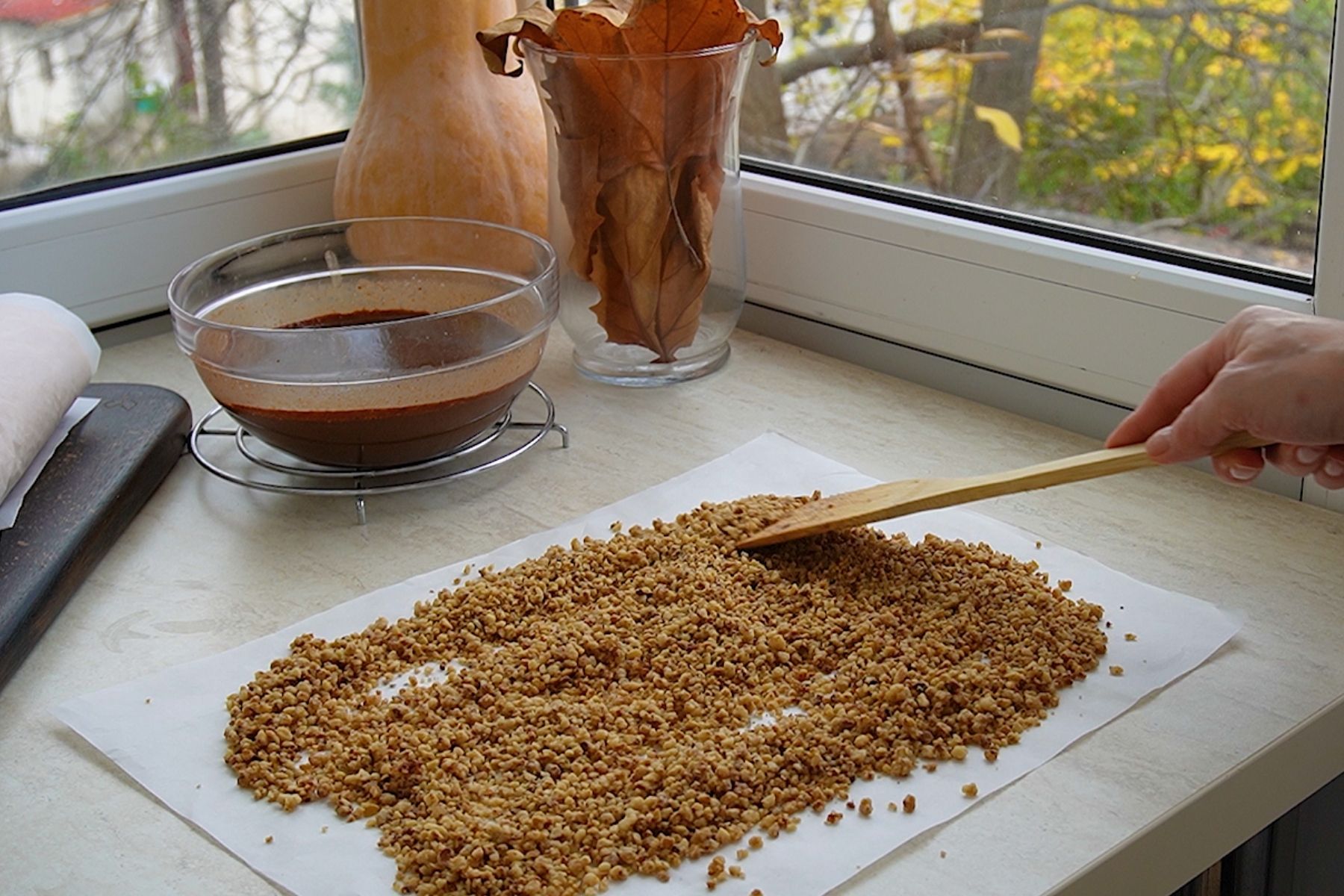 Nucile caramelizate pentru decorul ruladei sunt răspândite la răcit înainte de sfărâmare