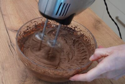 Ganache-ul de ciocolată este mixat până devine cremos pentru umplutura ruladei