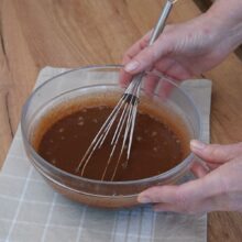 Crema ganache pentru rulada cu ciocolată este amestecată până devine omogenă după turnarea smântânii fierbinți