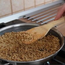 Miezul de nucă este caramelizat în tigaie pentru crocantul folosit la ruladă