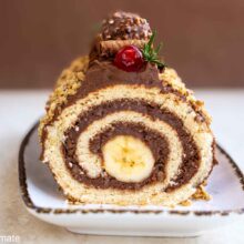 Ruladă cu cremă de ciocolată și banană în mijloc, decorată cu crocant de nuci - felie văzută în secțiune. Titlu SEO: