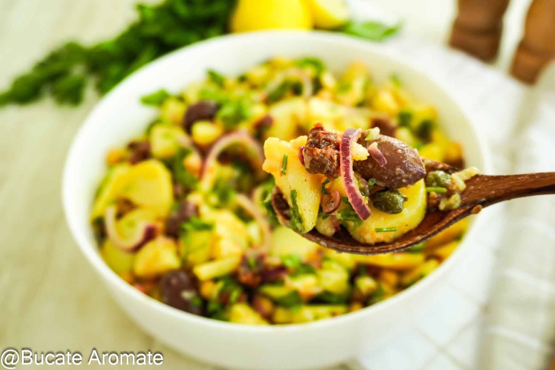 Lingură cu salată orientală de post, cu cartofi, năut, măsline, roșii uscate și capere