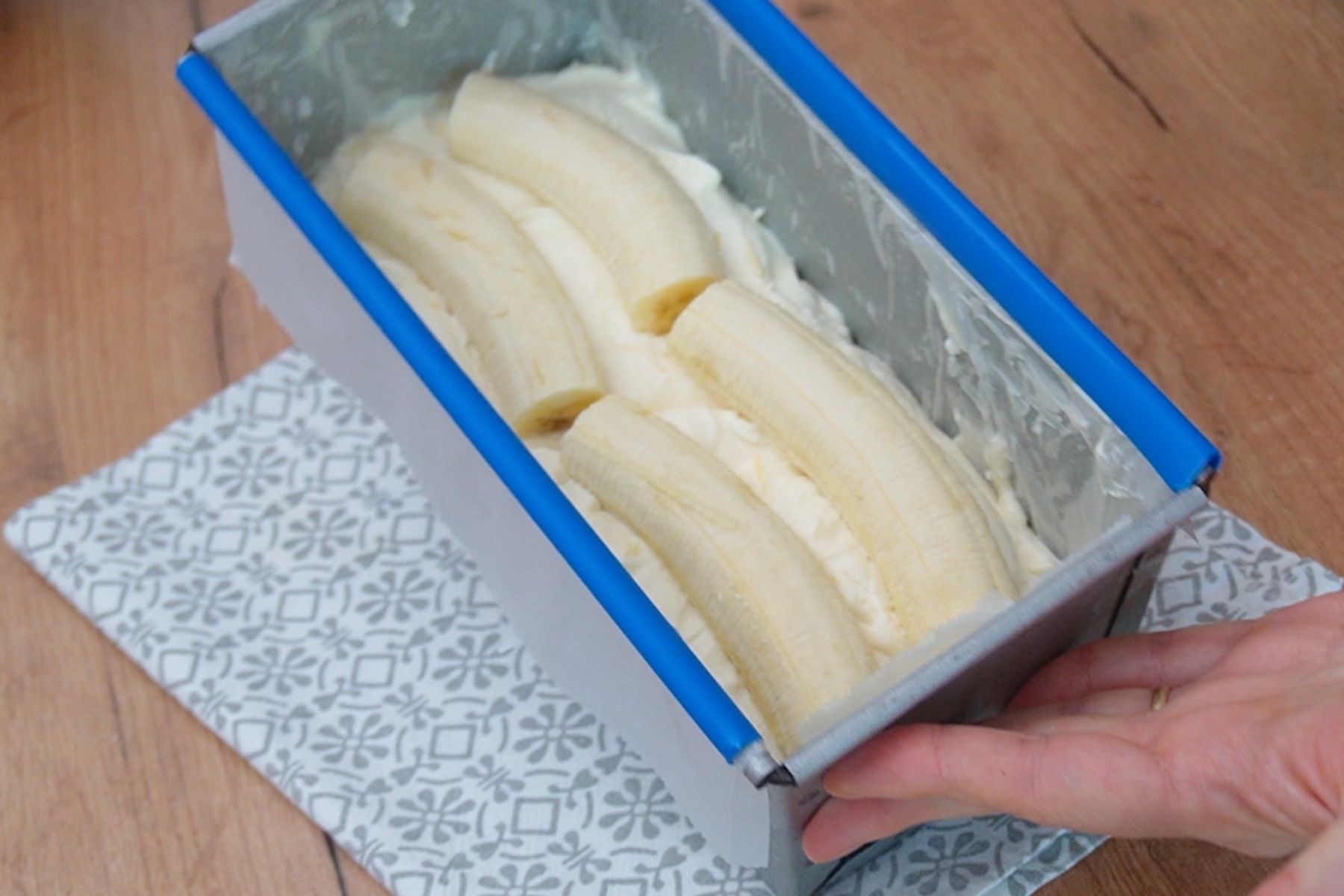 Banane întregi așezate peste crema de lapte condensat în prăjitura cu pișcoturi