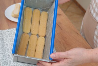 Pișcoturi de șampanie așezate pe fundul formei pentru prăjitură fără coacere