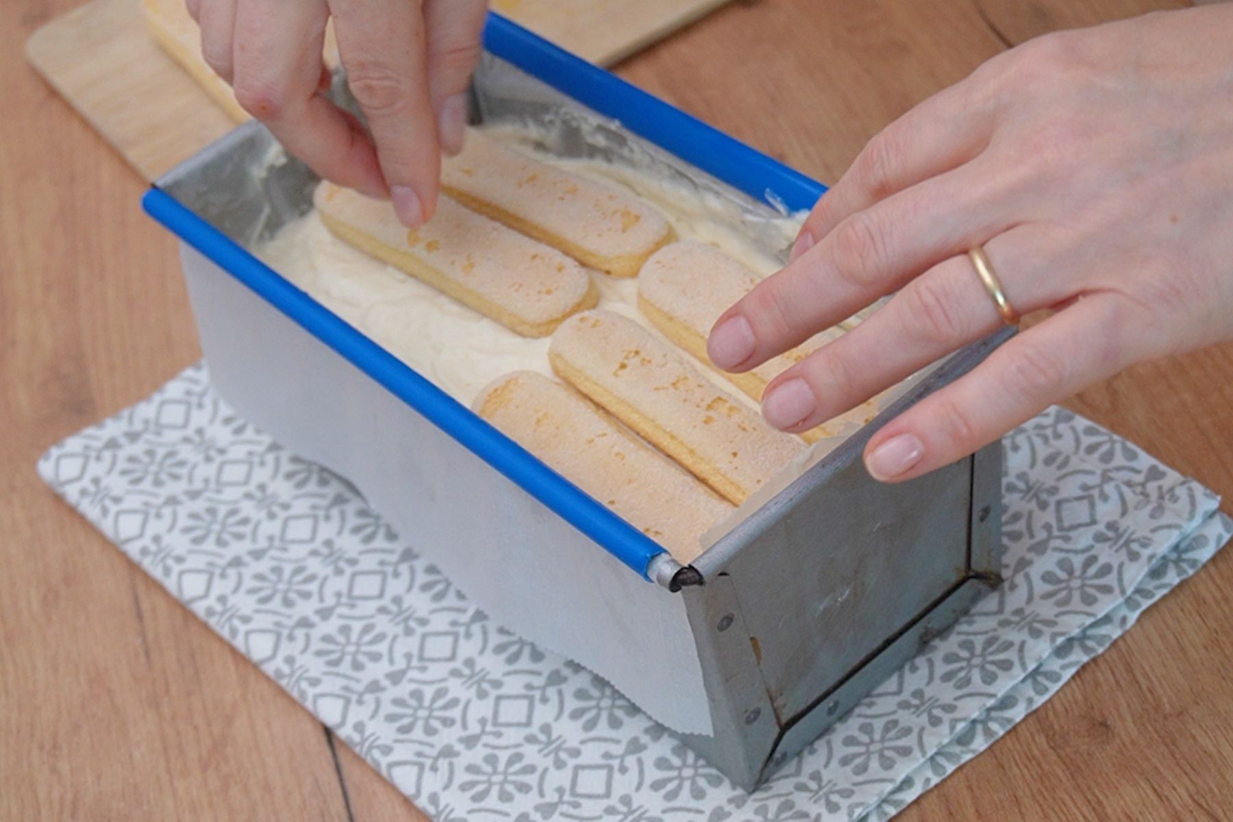 Strat final de pișcoturi așezat peste cremă la prăjitura cu banane