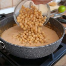 Adăugare boabe de năut fiert în sosul cremos de lapte de cocos și unt de arahide pentru curry de post