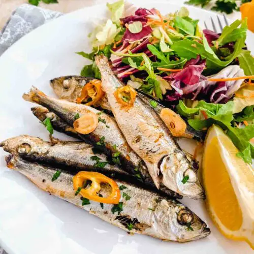 baby hering în farfurie cu salata si lamaie