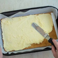 Strat de crema alba intinsa cu paleta peste foaie de aluat