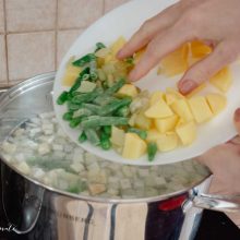 cuburi de cartofi si pastai adaugate in oala cu ciorba de curcan