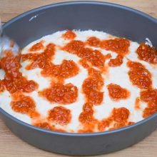 sos de roșii peste blat de pizza turnat în tavă