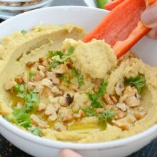 hummus cu dovlecei servit cu felii de ardei gras