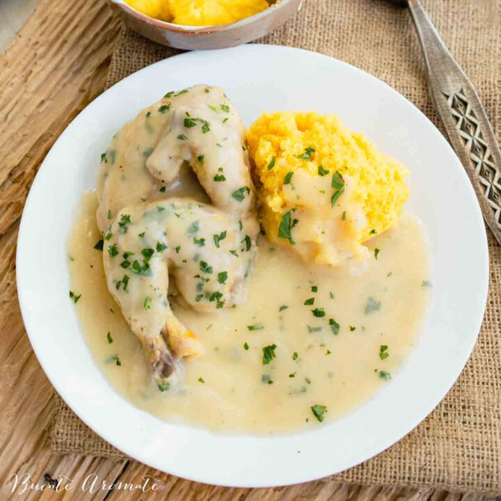 farfurie cu ciulama de pui traditionala si mamaliguta pe fund de lemn