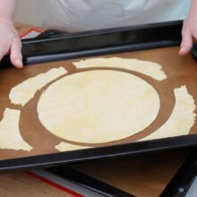 foaie de tort pusa in tava cu margini decupate - pregatita pentru coacere
