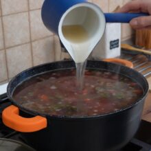 Borș fierbinte turnat peste legumele fierte în oală, pentru a da ciorbei gustul acrișor specific