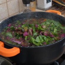 Cuburi de roșii, fasole fiartă și verdețuri tocate adăugate în ciorbă, înainte de a da în clocot