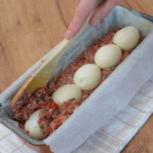 Compoziția de drob turnată pe jumătate in tava si 5 oua fierte asezate pe mijloc