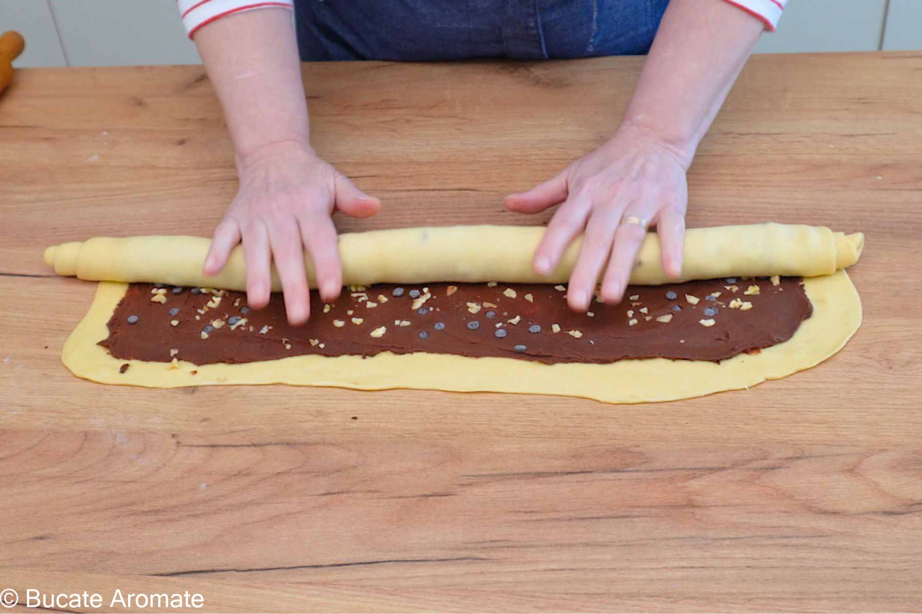 Aluatul de Babka rulat strâns pentru a crea straturi bine definite cu umplutură