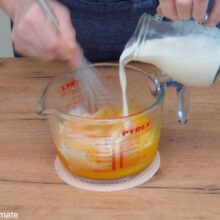 Oua, gălbenușuri, lapte, zahăr și vanilie amestecate într-un bol – primul pas din rețeta de Babka cu ciocolată