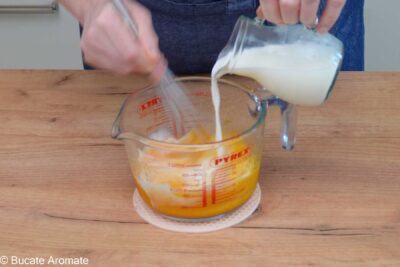 Oua, gălbenușuri, lapte, zahăr și vanilie amestecate într-un bol - primul pas din rețeta de Babka cu ciocolată