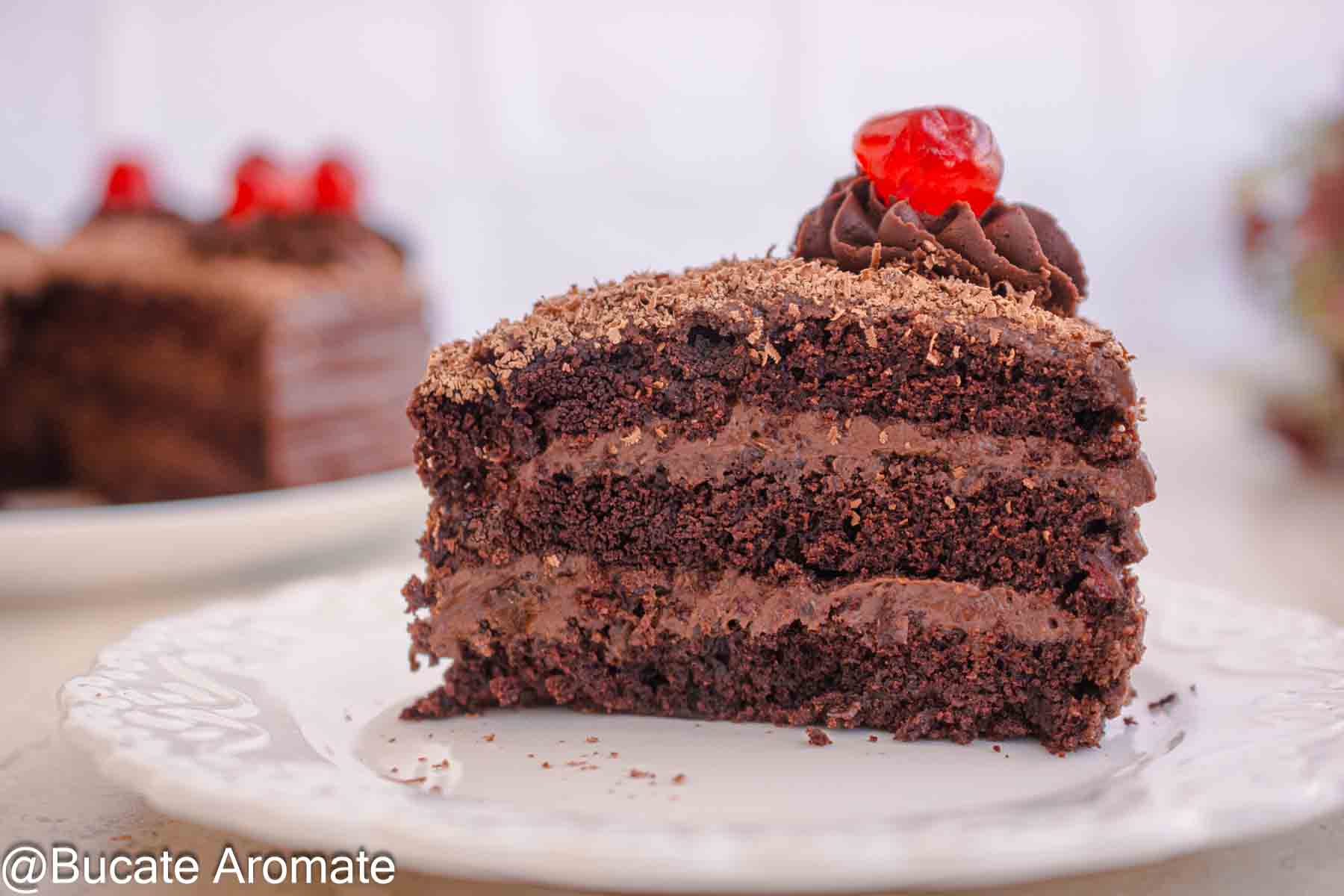 Felie de tort de post cu ciocolată, blat cu cacao în 3 straturi, cremă de ciocolată și decor cu cireașă confiată
