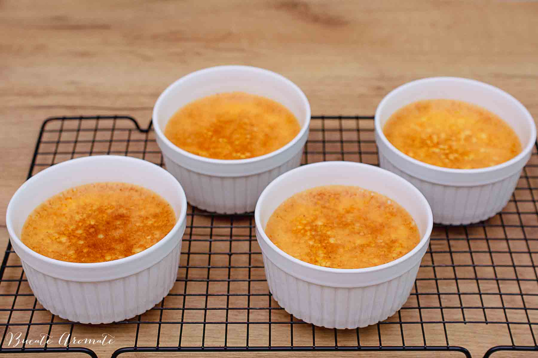 patru forme ceramice ramekin albe cu creme brulee pe gratar de racire