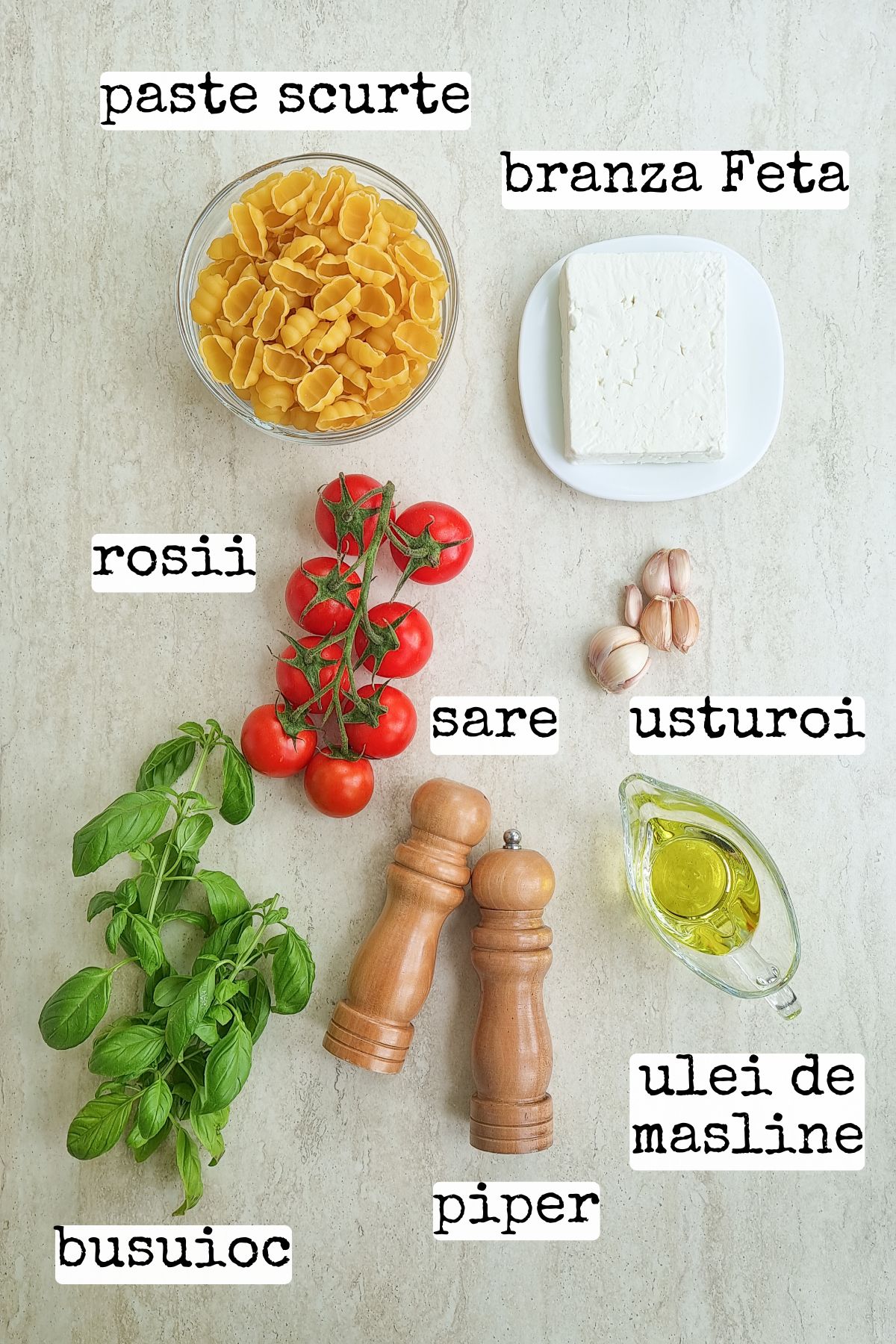 Ingrediente pentru paste cu Feta: paste scurte, roșii cherry, brânză Feta, usturoi, ulei de măsline, busuioc, sare și piper
