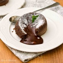 Lava cake cald, cu miez lichid de ciocolată, presărat cu zahăr pudră și frunze de mentă